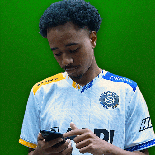 a man wearing a solari shirt looks at his cell phone