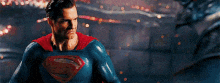 a close up of a man in a superman costume flying in the air .