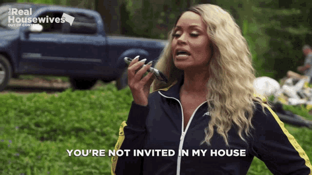 a woman speaking into a microphone with the words you 're not invited in my house