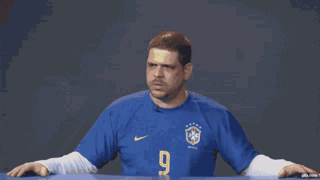 a man wearing a blue nike shirt with the number 9 on it