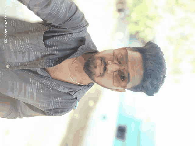 a man wearing glasses and a black shirt is taken by a vivo pro