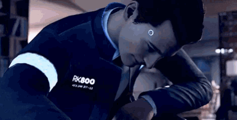 a man in a suit and tie with a rk800 badge on his jacket .