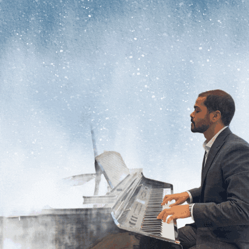 a man in a suit is playing a piano with a blue background
