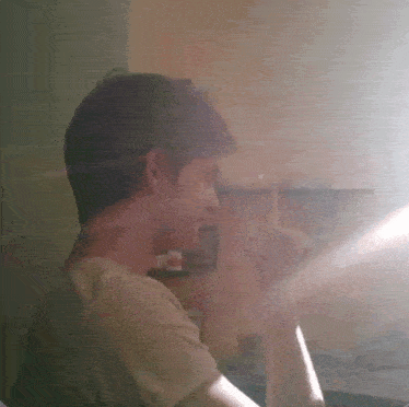a man in a white shirt is standing in front of a shelf with a picture on it