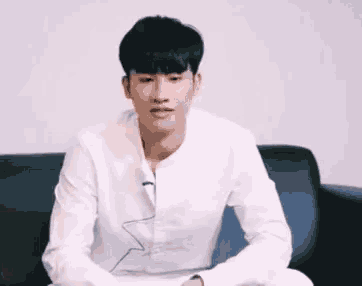 a man in a white shirt is sitting on a couch and saying " actually boyfriend "