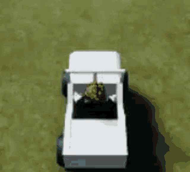 a white toy truck with a person sitting in the back seat .