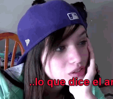 a girl wearing a purple hat with the words lo que dice el al on the bottom