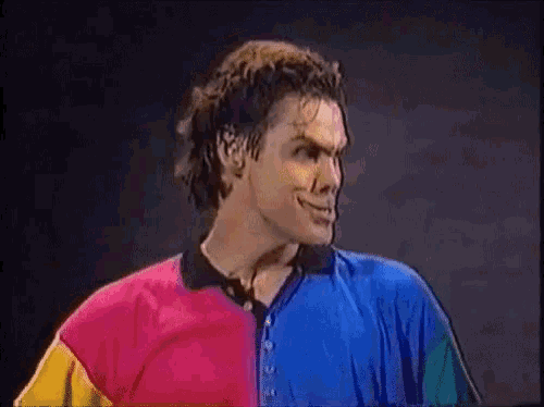 a man wearing a colorful shirt is making a face