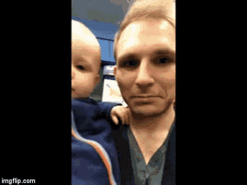 a man is holding a baby in his arms and the website imgflip.com is on the bottom of the screen