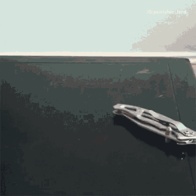 a pair of pliers laying on a black surface with a caption that says ig punisher_izrd
