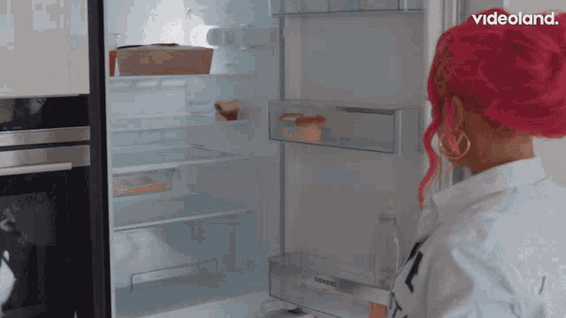 a woman with pink hair opens a siemens refrigerator door