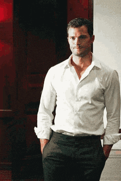 a man in a white shirt and black pants is standing in front of a red door