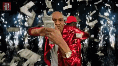 a man in a red jacket is holding a stack of money in front of a bbc logo