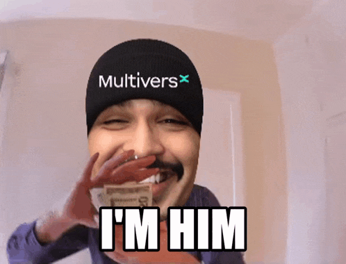 a man wearing a beanie that says multivers holds a pile of money