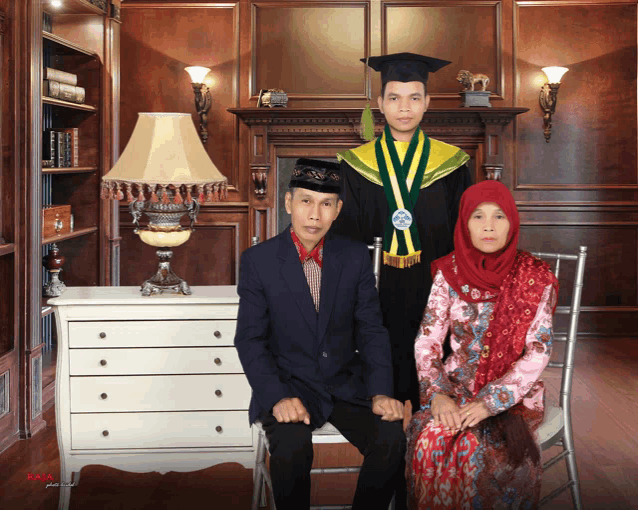 a man in a graduation cap and gown stands with his parents