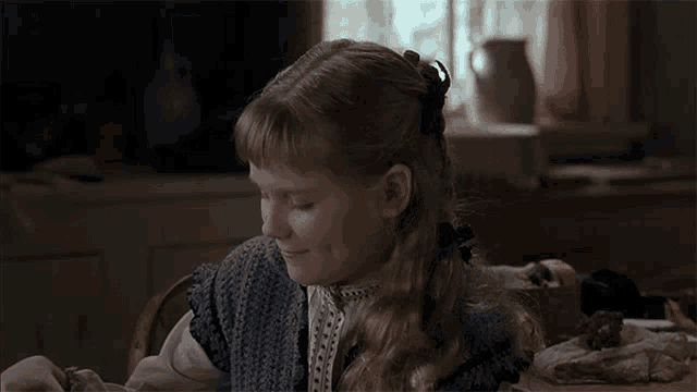 a little girl sitting in a chair with her eyes closed