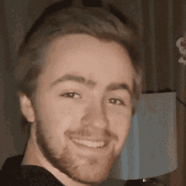 a close up of a man 's face with a lamp in the background