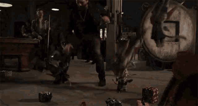 a group of people are fighting each other in a room with a statue in the background .