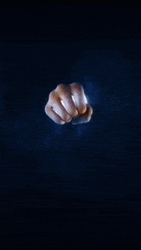 a hand is holding a glowing sphere that looks like a clock