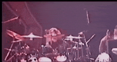 a drum set is being played on a stage in a dark room .
