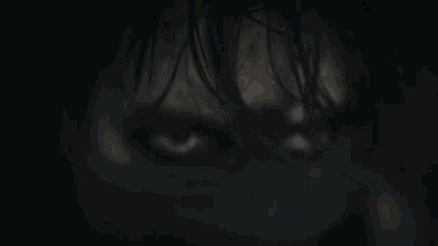 a close up of a person 's face with their eyes glowing in the dark .