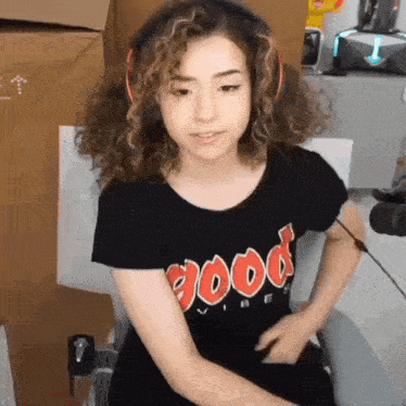 a girl with curly hair is wearing headphones and a black shirt that says good