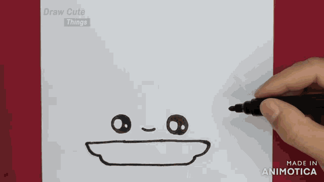 a person is holding a marker and drawing a face on a piece of paper