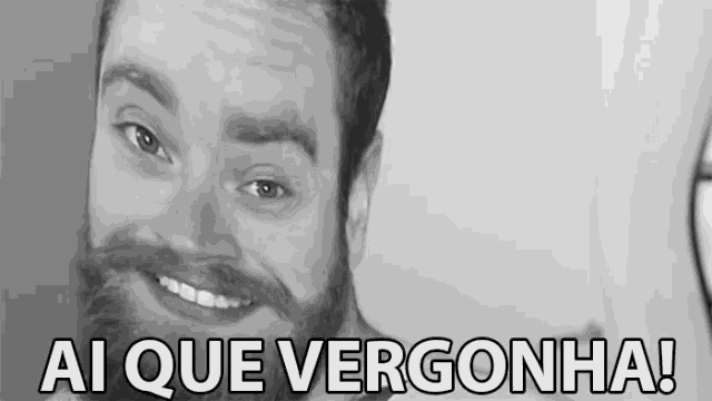 a man with a beard is smiling with the words ai que vergonha written below him