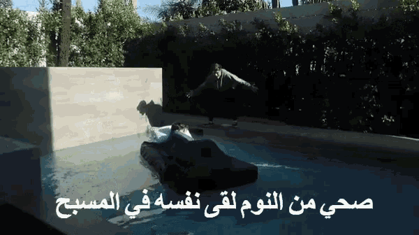 a man is floating in a pool with arabic writing on the bottom