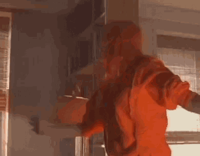 a person in an orange hoodie is standing in a room .