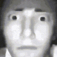 a black and white photo of a person 's face with a very serious look on their face .