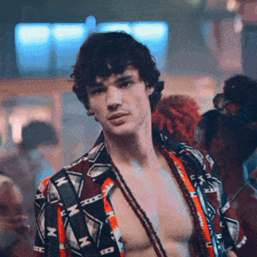 a shirtless man with a necklace around his neck is wearing a shirt with the letter m on it