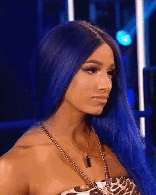 a woman with blue hair is wearing a necklace