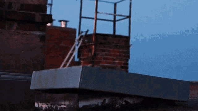 a brick chimney with a ladder going up it