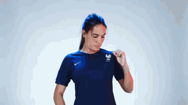 a woman wearing a blue nike shirt with a rooster on the front