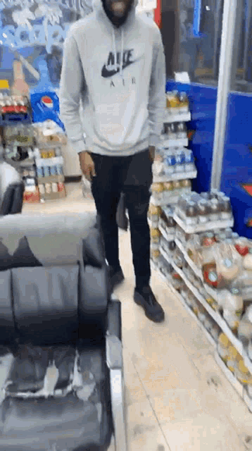 a man wearing a nike air hoodie stands in a store