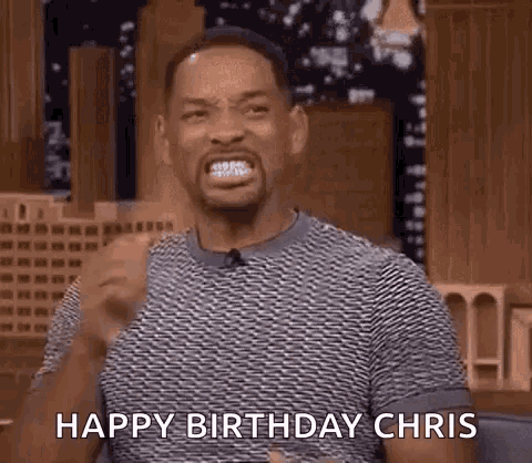 will smith is making a funny face and saying `` happy birthday chris '' while sitting on a stage .