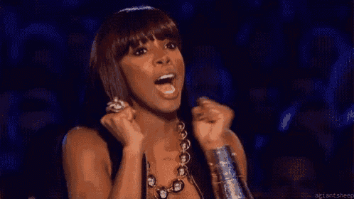 a woman is holding her fists in the air and screaming .