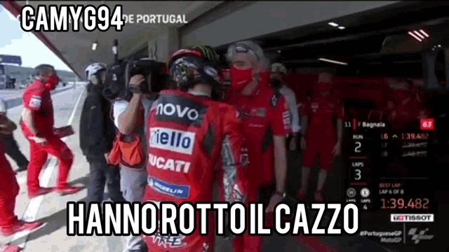 a man in a red ducati jacket stands in a garage