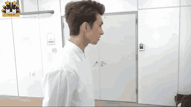 a man in a white shirt is standing in a room with a sign that says no smoking