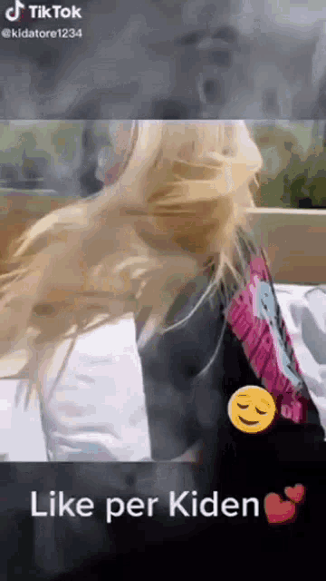 a woman is laying on a bed with her hair blowing in the wind and a smiley face .