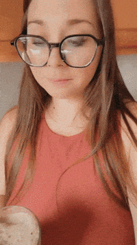 a woman wearing glasses is holding a glass