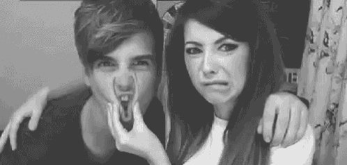 a black and white photo of a boy and a girl making funny faces .