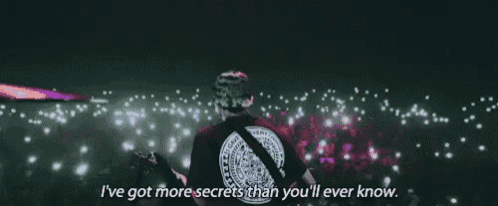 a man is standing in front of a crowd with the words i 've got more secrets than you 'll ever know .