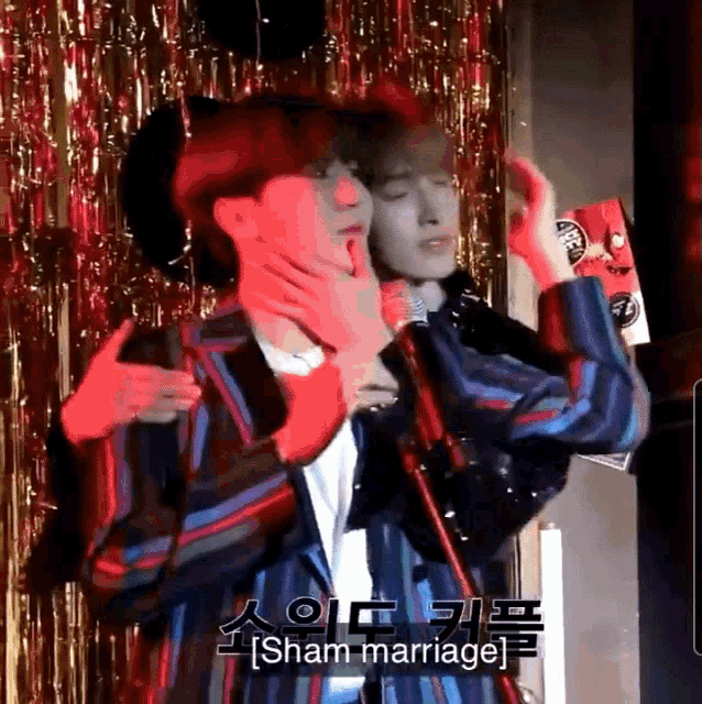 a man in a striped jacket is holding another man 's neck and the words sham marriage are on the bottom