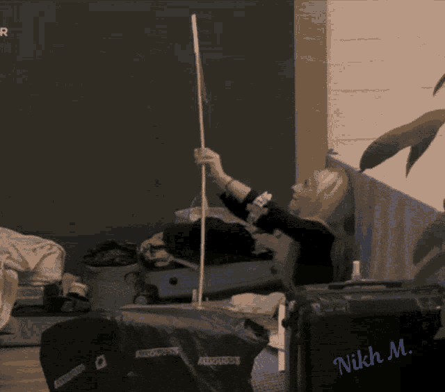a woman laying on a couch holding a stick with the name nikki m. on the bottom right