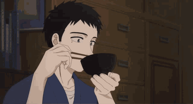 a man with chopsticks eating from a bowl