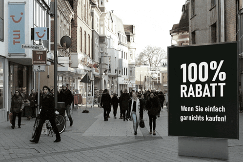 people walking down a street with a sign that says " 100 % rabatt "