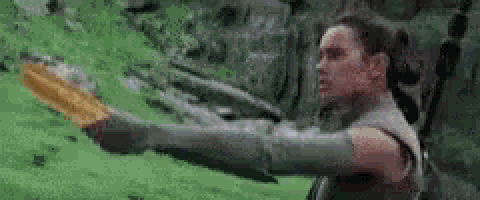 a woman is standing in a field holding a sword .