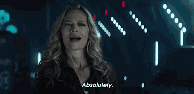 a woman says " absolutely " in front of a dark background
